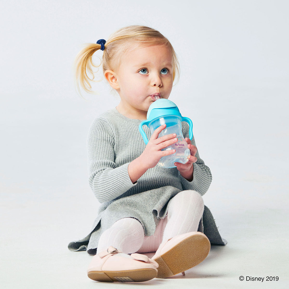 シッピーカップエルサデザインのマグを飲む女の子