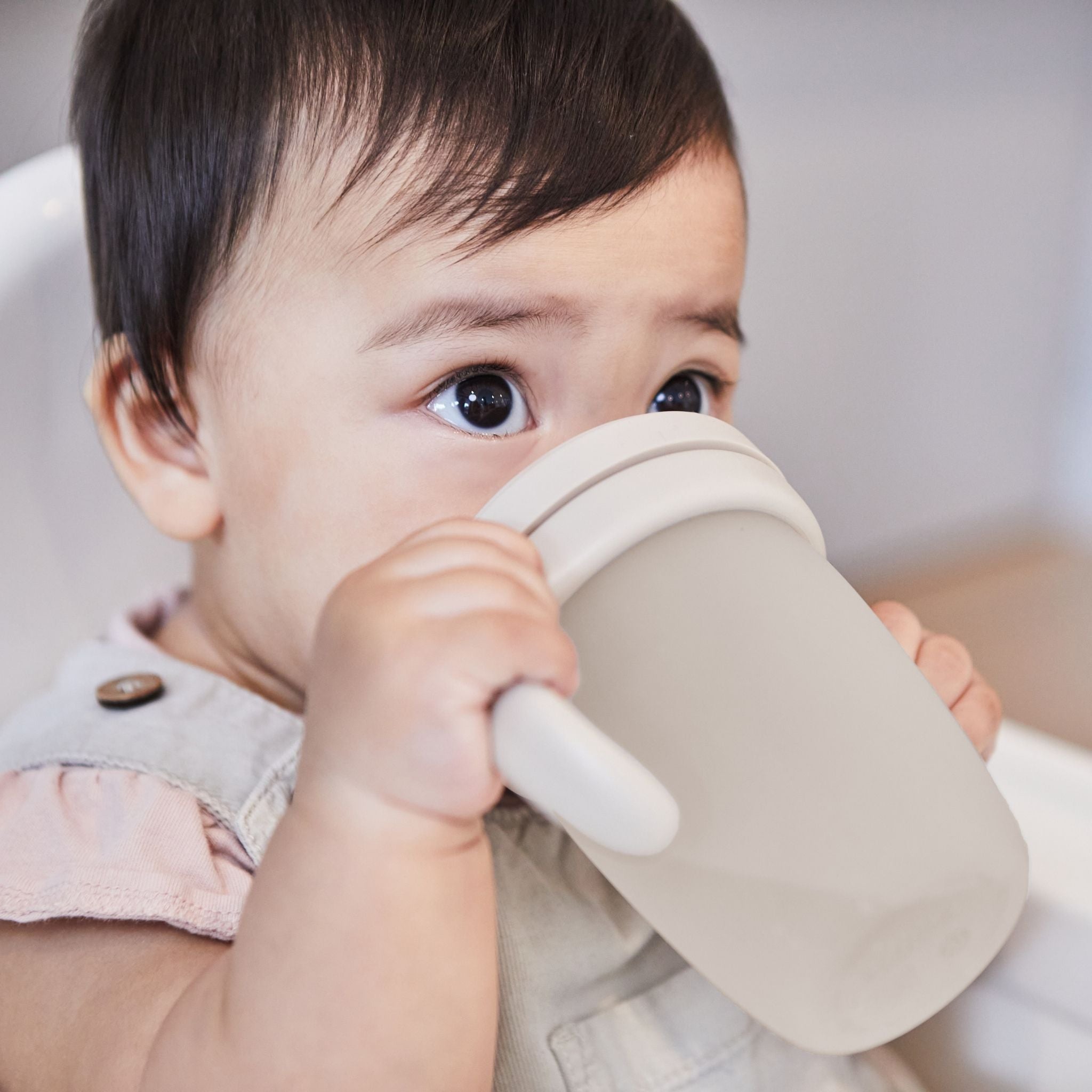 ハンドル付きシリコンスパウトカップlatteカラーを飲む女の子