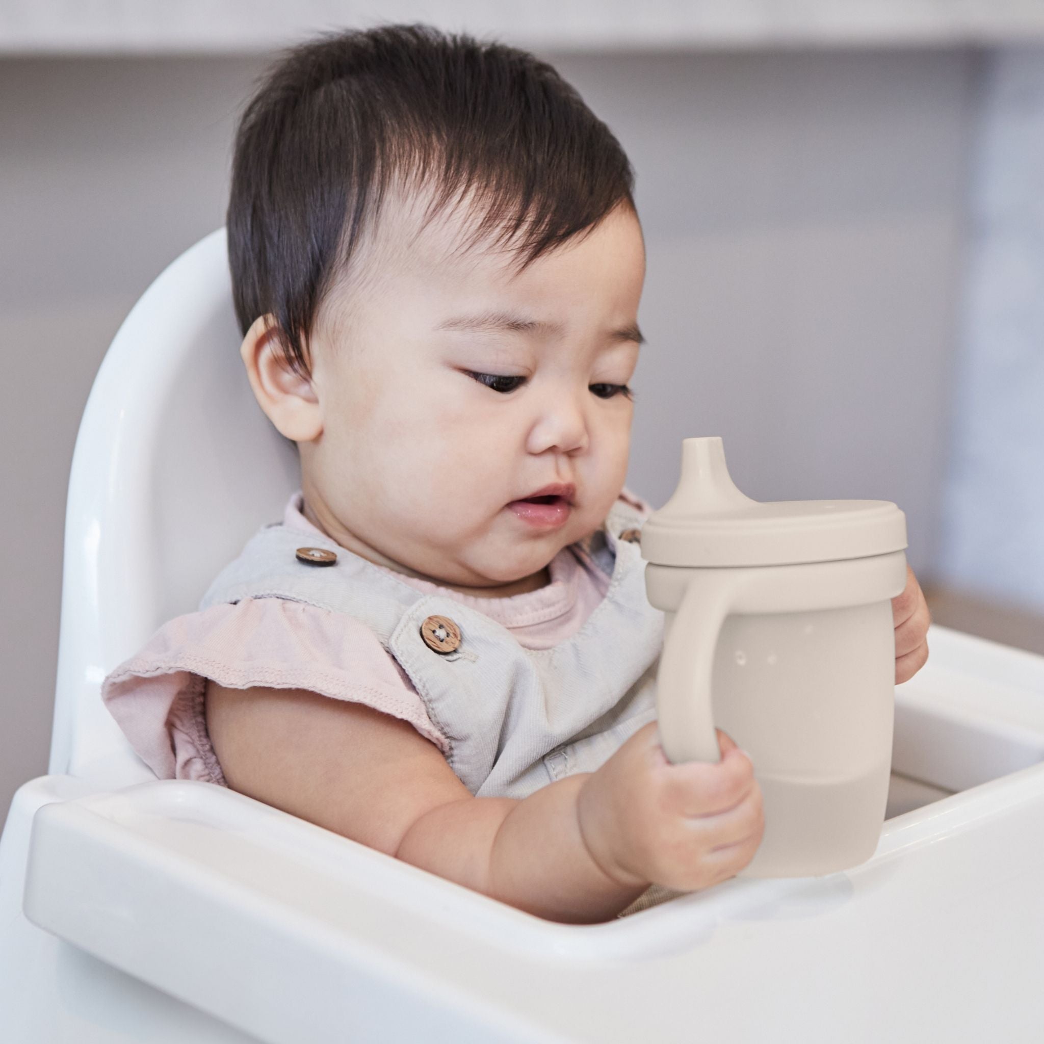ハンドル付きシリコンスパウトカップlatteカラーを飲む女の子