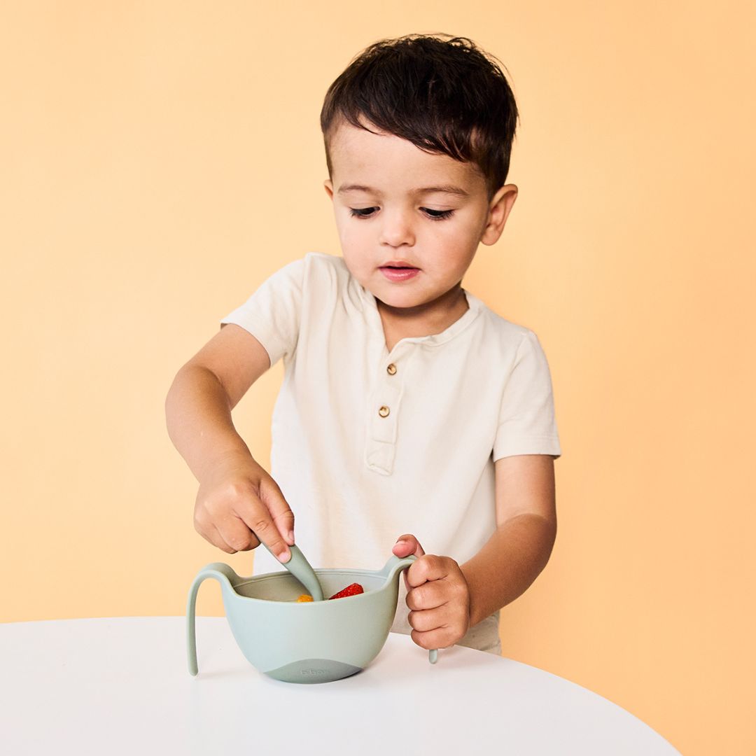 ビーボックスのシップスナックボウルを左手に持ってカトラリーを使っている男の子