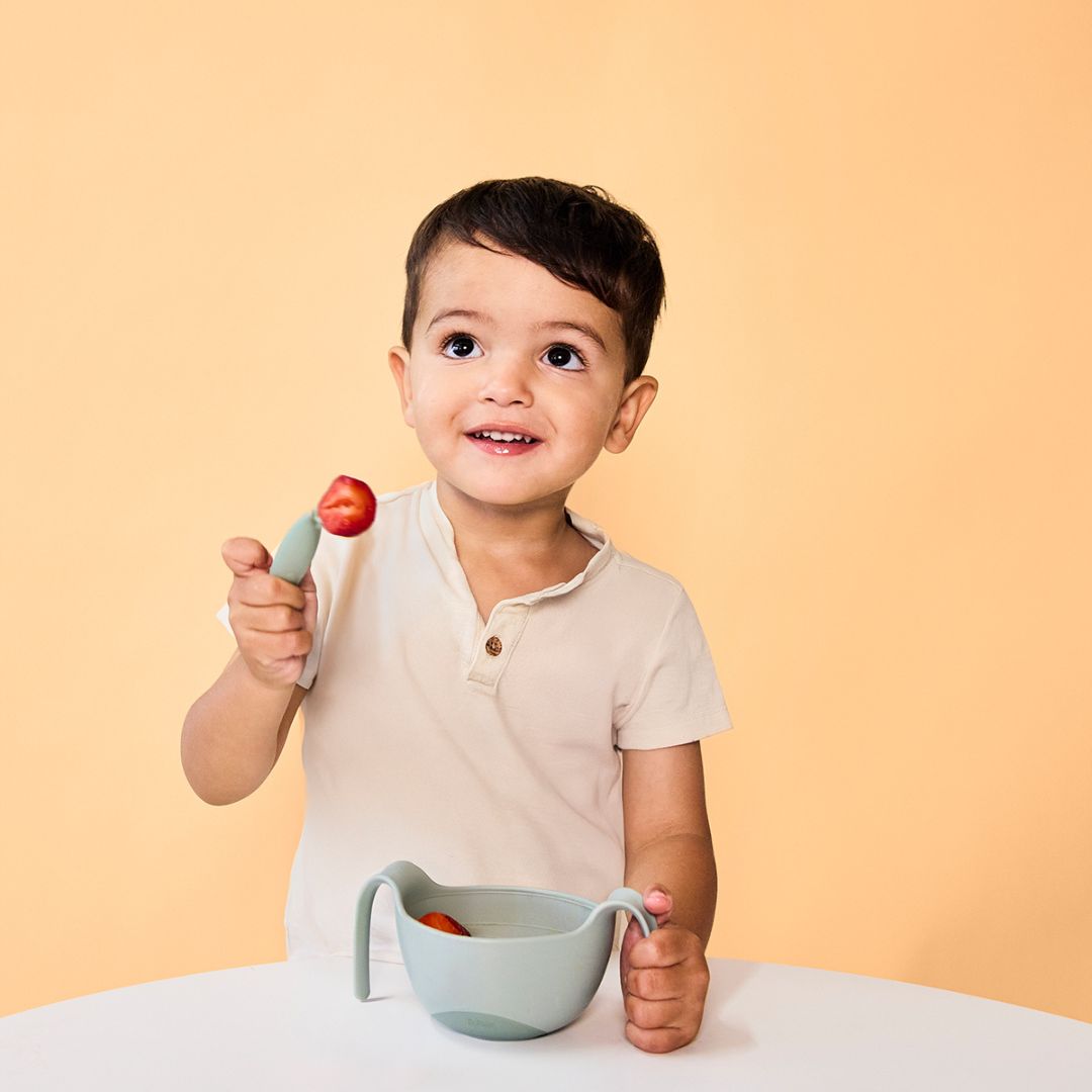 ビーボックスのシップスナックボウルを左手に持って、とカトラリーを使っている男の子