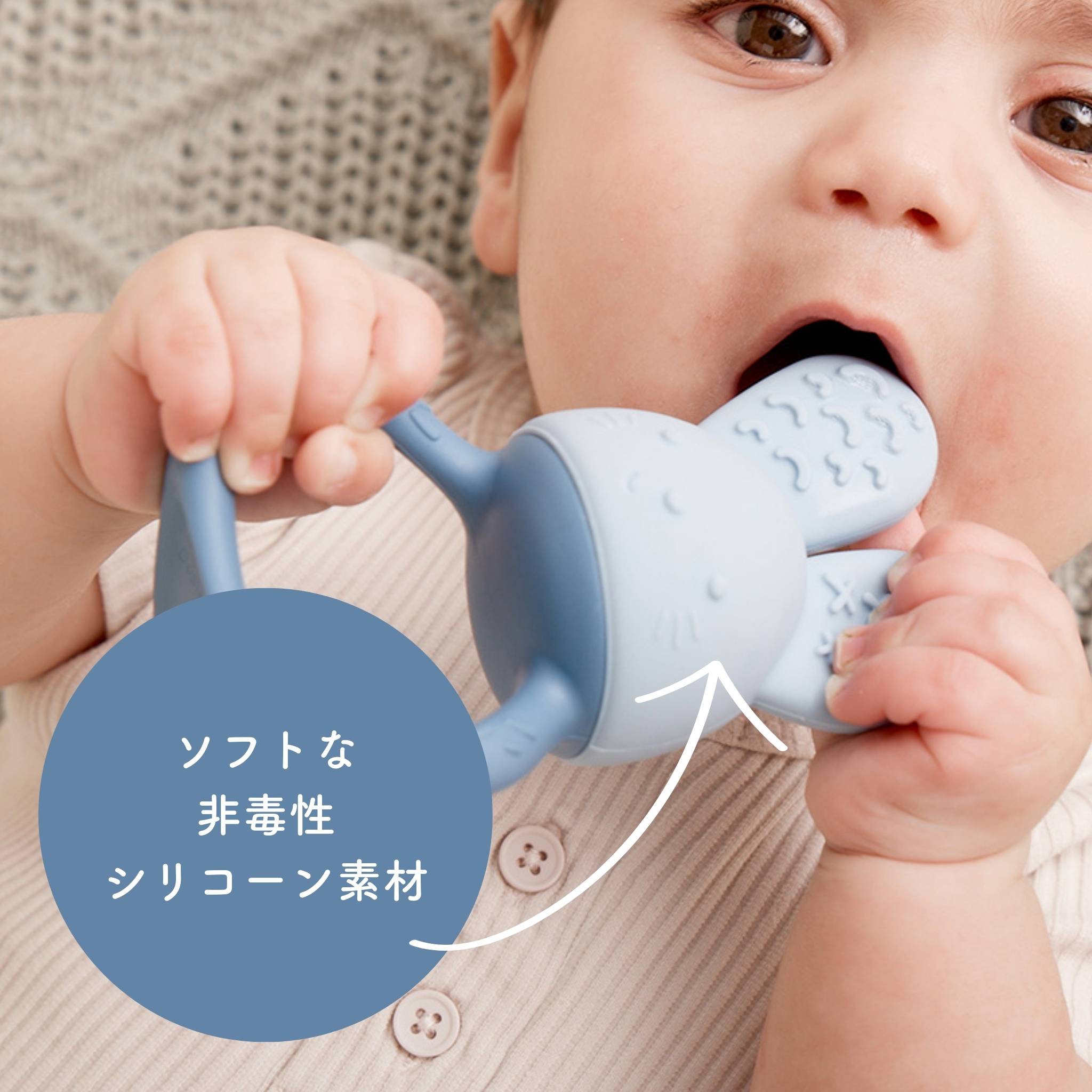 赤ちゃんが柔らかい非毒性のシリコーン素材の歯固めを噛んでいる