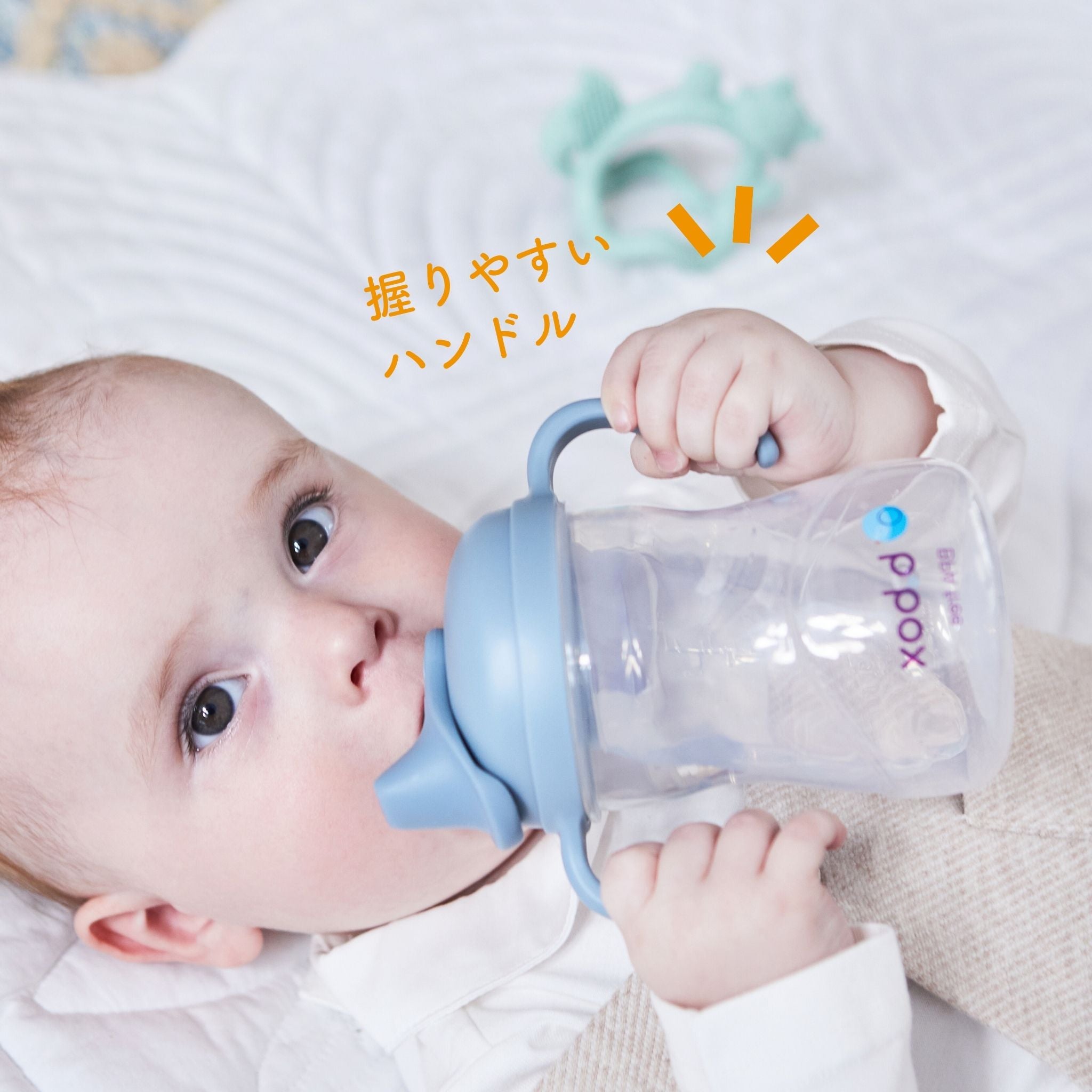 赤ちゃんがスパウトボトルを握っている写真