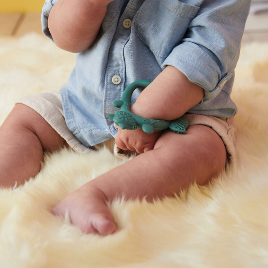 リストティーサー(歯固め)のsageカラーを腕にはめている赤ちゃんの手