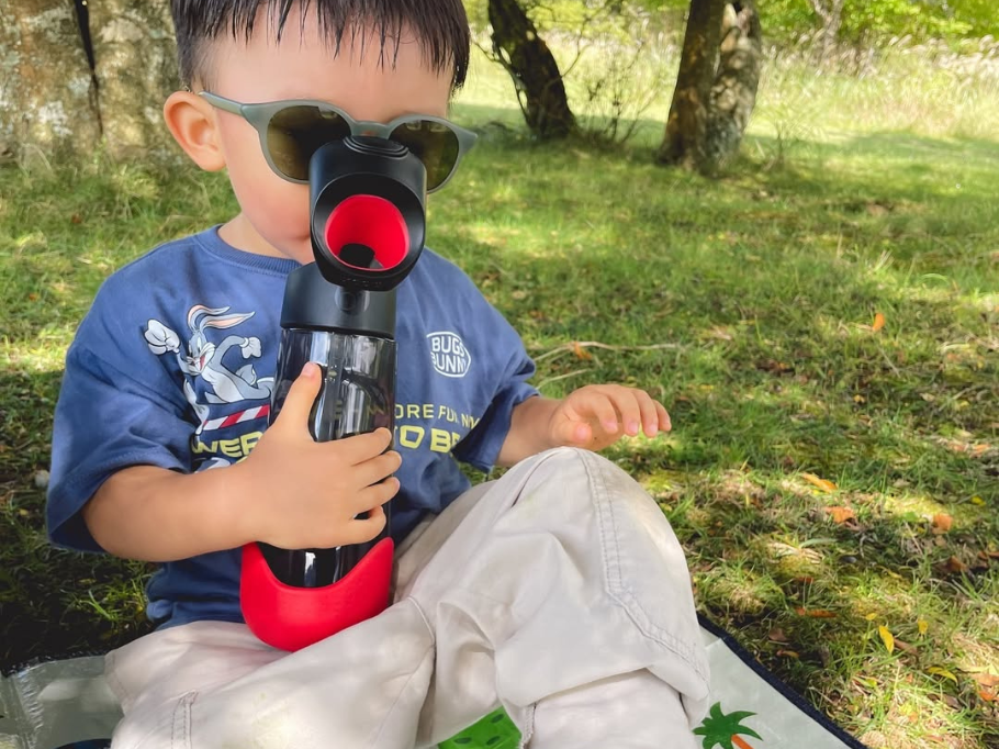 子どもが水稲から水を飲んでいる画像