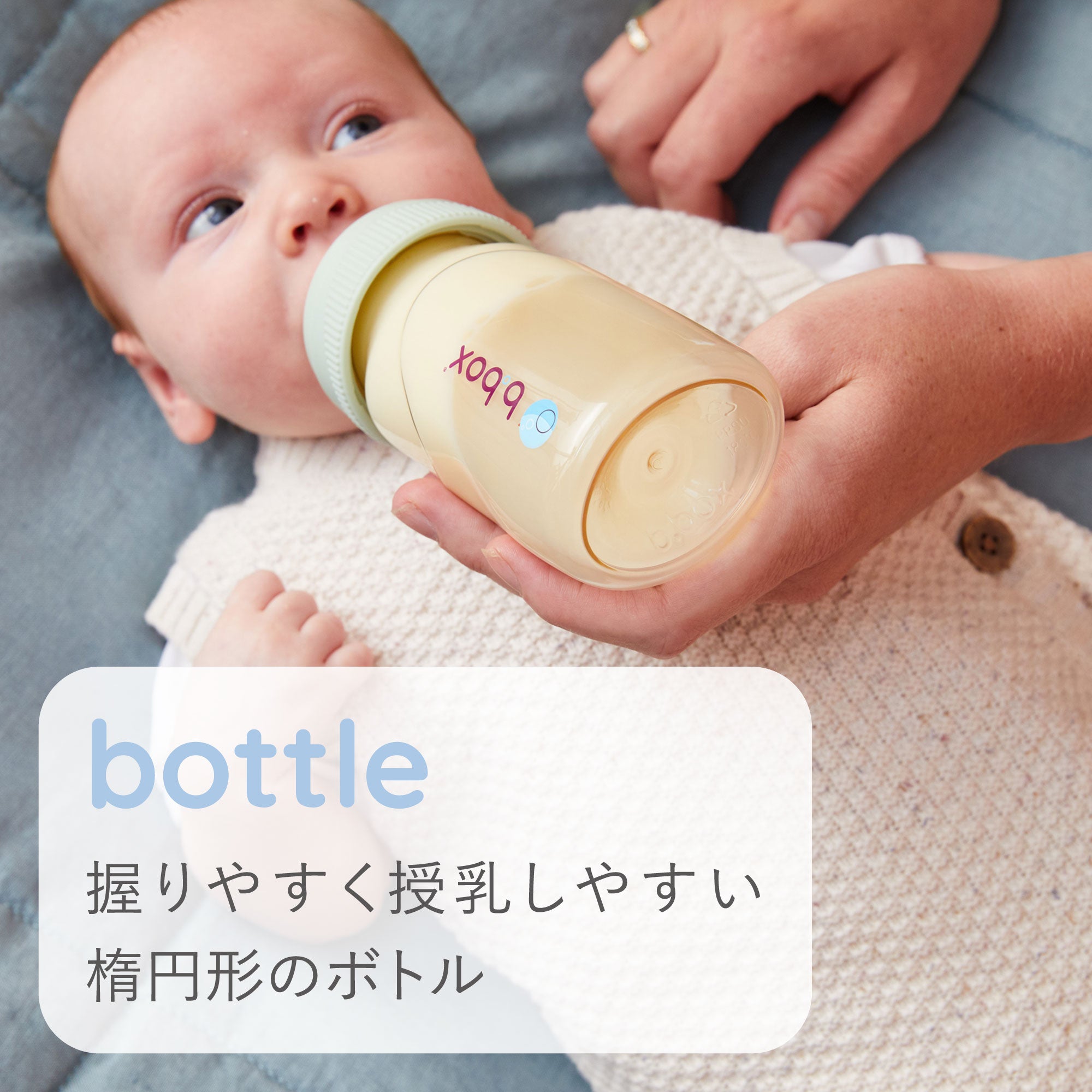 寝転がった赤ちゃんに楕円形で授乳しやすいビーボックスの哺乳瓶で授乳をしている様子