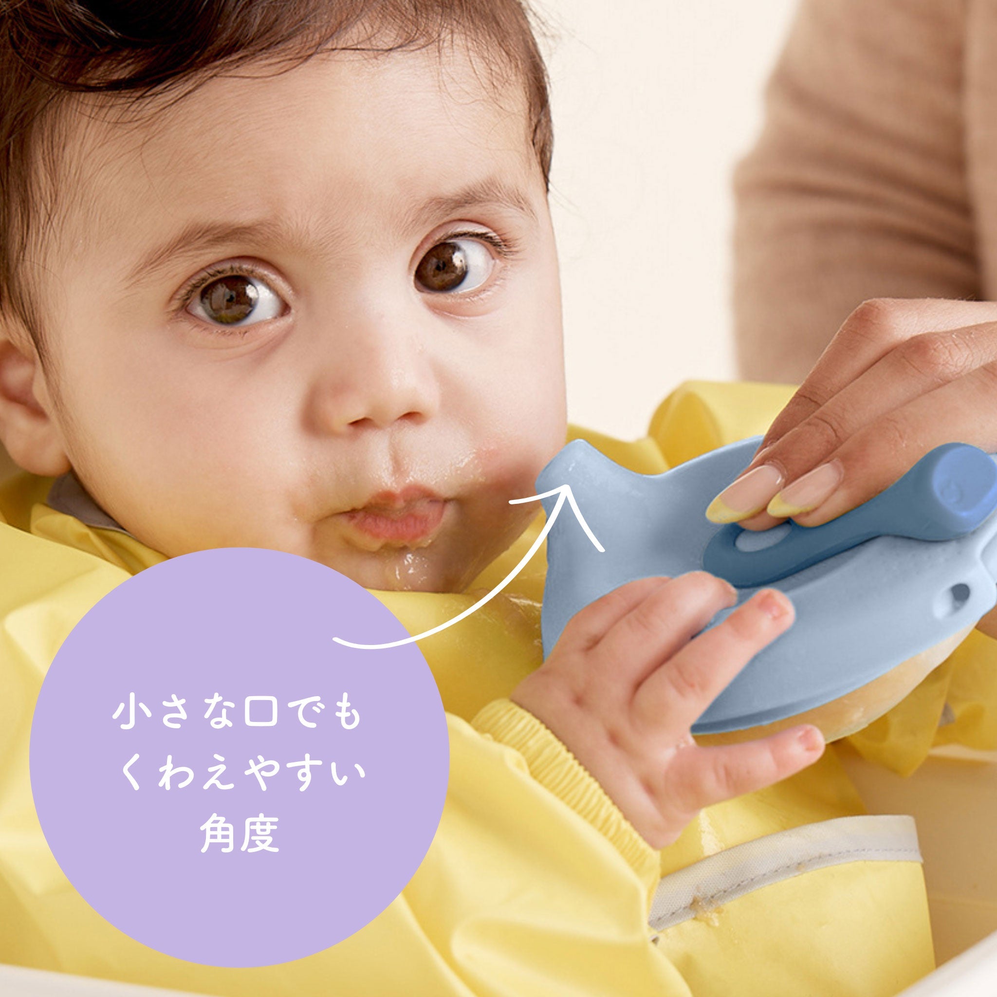 赤ちゃんが離乳食容器で食事をしているところ。容器は赤ちゃんの口に合わせてくわえやすい角度になっていると説明している。