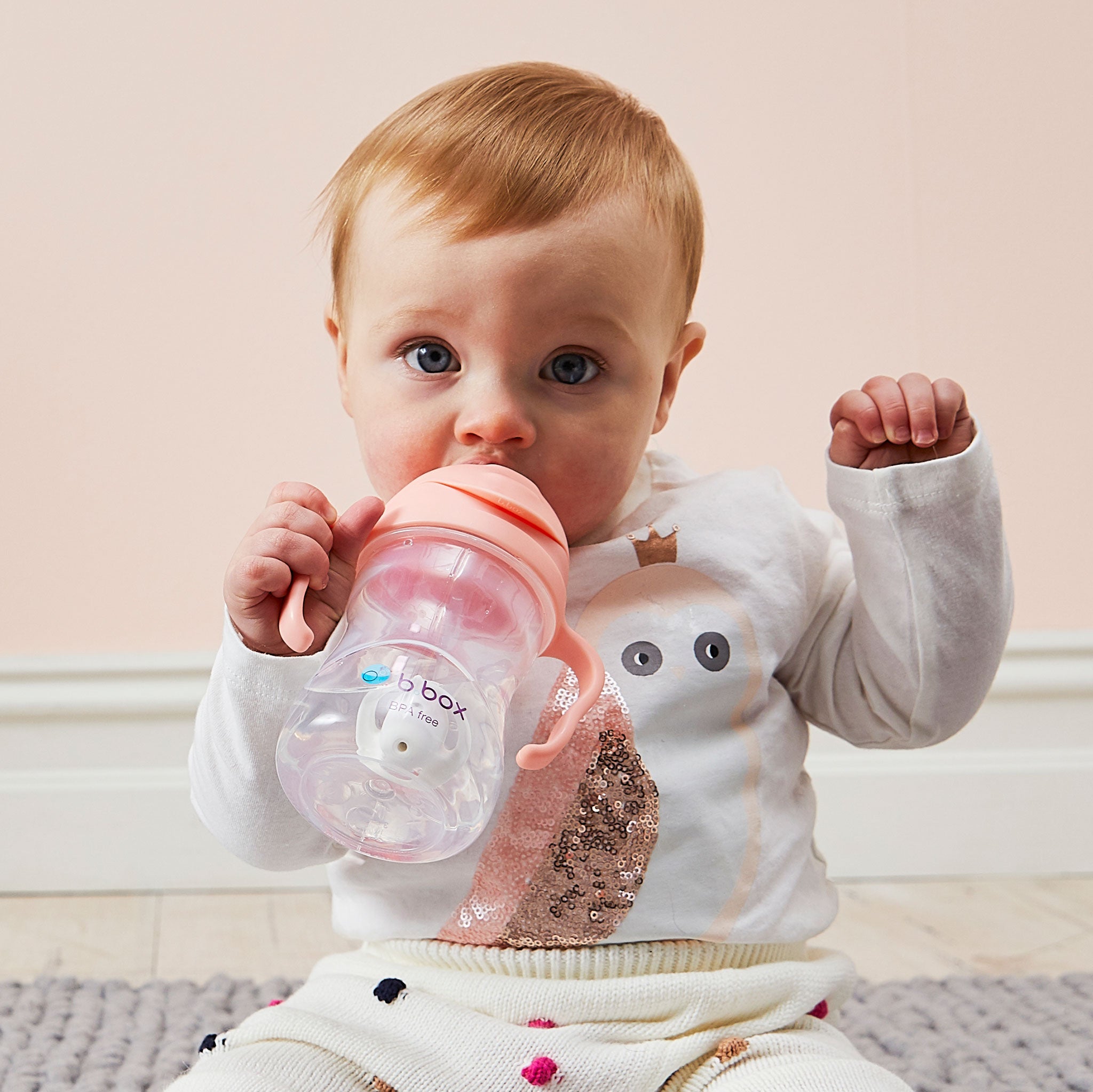 ビーボックスのマグtuttifruttiを持って飲んでいる女の子の赤ちゃん