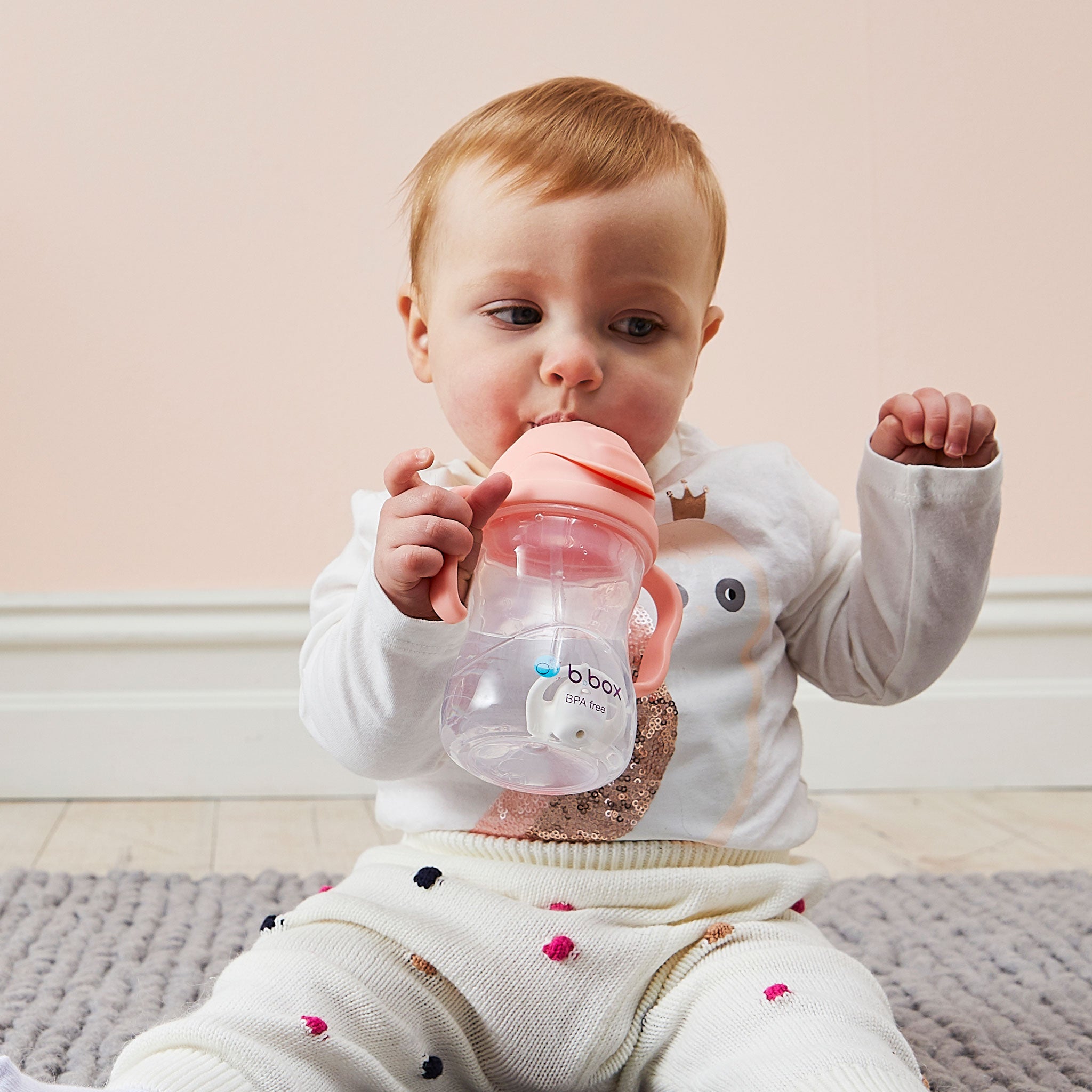 ビーボックスのマグtuttifruttiを持って飲んでいる女の子の赤ちゃん