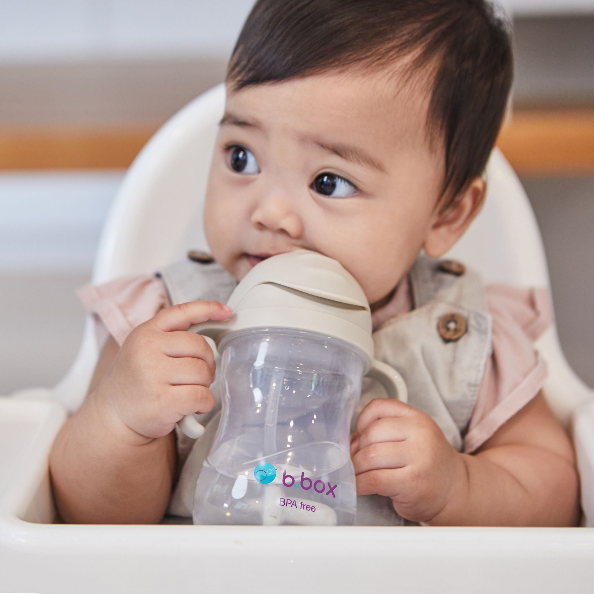 シッピーカップのlatteカラーを飲んでいる女の子の赤ちゃん